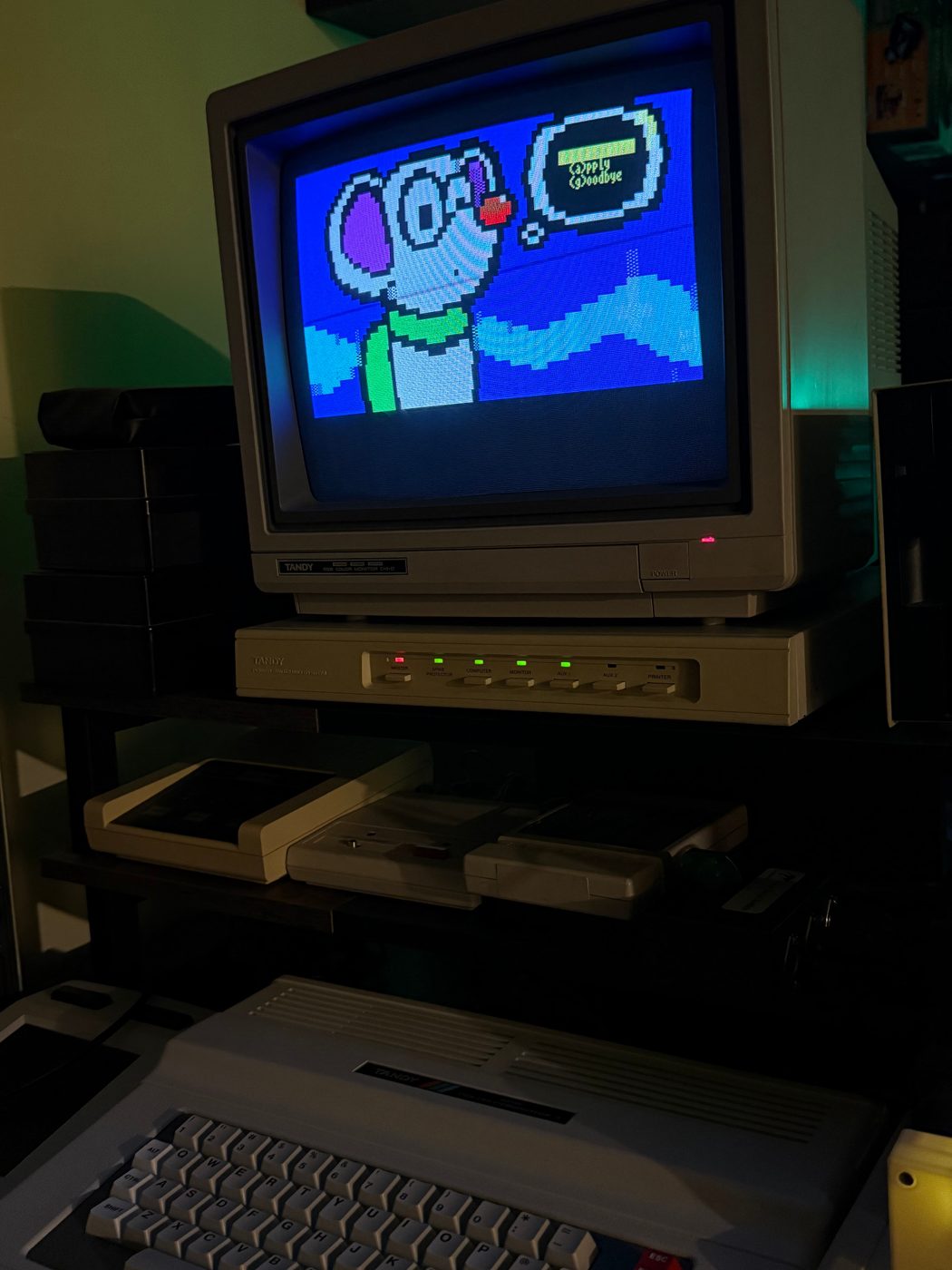 CoCo 3 monitor displaying colorful ANSI artwork during a GiME ANSi BBS session