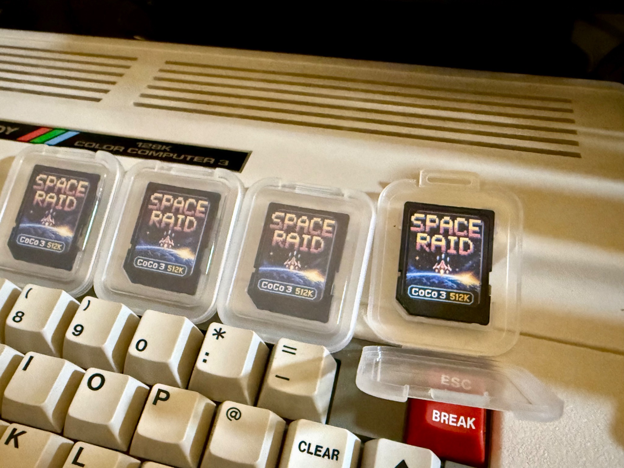 Space Raid limited-run SD cards pictured with a Tandy Color Computer 3